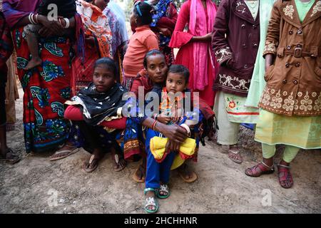 Rajshahi, Bangladesch. 28th Dez 2021. Frau und ihre Kinder genießen es, den traditionellen Gruppentanz bei einer Hochzeit in Rajshahi zu beobachten.der Stamm der Santal ist eine ethnische Gruppe, die in Ostindien beheimatet ist. Santals sind in Bezug auf die Bevölkerung der größte Stamm im Bundesstaat Jharkhand in Indien und werden auch in den Staaten Assam, Tripura, Bihar, Odisha und Westbengalen gefunden. Sie sind die größte ethnische Minderheit in der Rajshahi-Division und der Rangpur-Division im Norden Bangladeschs. Kredit: SOPA Images Limited/Alamy Live Nachrichten Stockfoto