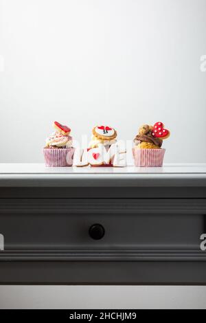 Muffins, Cupcakes und plätzchenförmige Wort Liebe und Herzen, romantisches Dessert-Geschenk Stockfoto