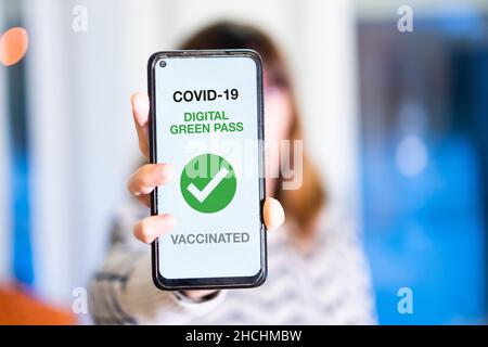 Grüner Pass der covid-19, zeigt eine Frau ein Handy mit dem Gesundheitspass. Impfpass für Bars und Restaurants, Coronavirus Stockfoto