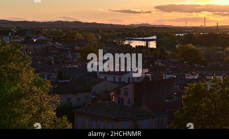 Schöner Blick über die Dächer des historischen Zentrums von Avignon, Provence, Frankreich im Herbst bei Sonnenuntergang mit orangefarbenem Himmel. Stockfoto