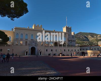 Blick auf den berühmten Fürstenpalast von Monaco, die offizielle Residenz des Fürsten, am Nachmittag mit Touristen zu Fuß und Berge. Stockfoto