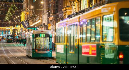 Helsinki, Finnland. Die Straßenbahn fährt von der Haltestelle Aleksanterinkatu Straße. Nacht Abend Weihnachten neues Jahr festliche Beleuchtung auf der Straße. Schöne Stockfoto