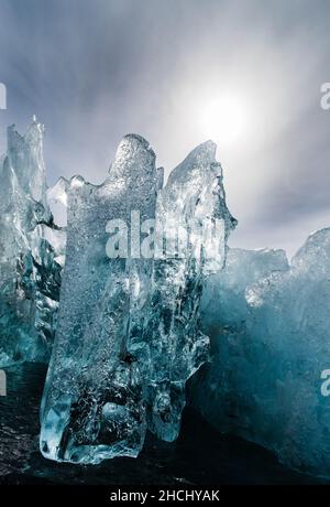 Ein Detailfoto eines kleinen Bereichs eines umgedrehten Eisbergs mit klarem und schwarzem Eis und Hintergrundbeleuchtung in Paradise Bay, Antarktis Stockfoto