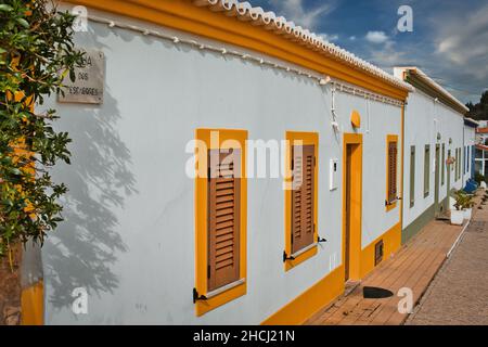 Alte, weiß getünchte Fischerhütten mit bunten Türen und Fenstern im ehemaligen Fischerdorf Benagil an der Algarve. Stockfoto