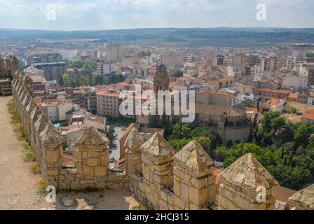 Almansa, Albacete, Spanien - Blick von der Burgmauer auf Kirche und Stadtgebäude, mit Ebenen in der Ferne. Stockfoto