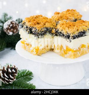 Weihnachtskäsekuchen mit Pfirsichen, Kokosnuss und Mohn. Stockfoto