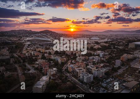 Sonnenuntergangs-Luftaufnahme von Nord-Athen mit olympischem OAKA-Komplex im Hintergrund. Athen, Griechenland Stockfoto