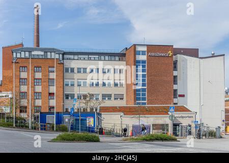 Sodertalje, Schweden - 11. Mai 2021: Ein Schild auf dem Gebäude mit dem AstraZenecas-Logo und Haupttor Stockfoto