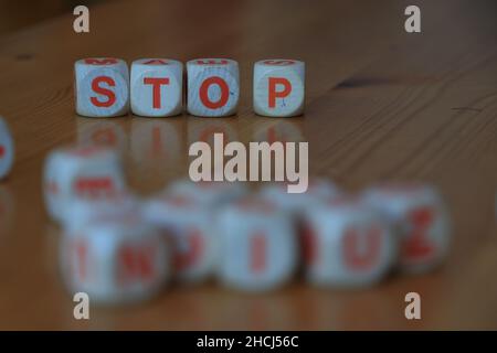 Hölzerne orange und weiße Buchstabenwürfel bilden das Wort "Stop" auf Holzhintergrund. Hochwertige Fotos Stockfoto