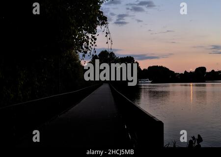 Durchgang mit Bäumen auf einem See bei Sonnenuntergang im Herbst Stockfoto