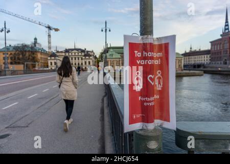 Stockholm, Schweden - 10. Mai 2021:Ein laminiertes Schild auf dem Laternenpfahl in der Nähe des parlaments mit dem Text, der besagt, dass man füreinander aufpassen muss! Halten Sie die verbleibende Distanz ein Stockfoto