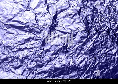Hintergrundtextur aus zerknitterter Aluminiumfolie mit getönten, sehr peri-Hervorhebungen, Nahaufnahme. Stockfoto
