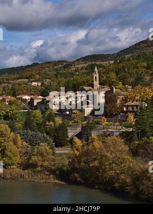 Schöne Aussicht auf ein kleines Dorf mit Kirche und traditionellen Gebäuden, Teil der Stadt Sisteron, Provence, Frankreich, umgeben von bunten Bäumen im Herbst. Stockfoto