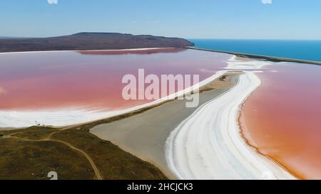 Panorama-Luftaufnahme der hellen Farbe berühmten natürlichen Ort - rosa See auf der Krim mit erstaunlichen Küste und türkisfarbenem Meer auf dem Hintergrund. Einzigartiger pi Stockfoto