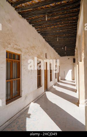 Schöner sonniger Korridor mit braunen Holzfenstern an beigefarbenen alten Wänden Stockfoto