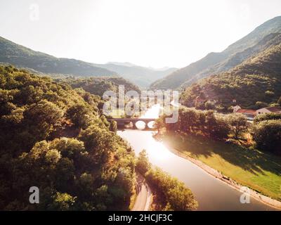 Brücke über den Fluss Crnojevica inmitten grüner Berge. Montenegro Stockfoto