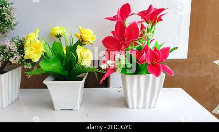 Künstlicher Strauß von Rosen und Lilien in Töpfen, Innen- und Außendekoration. Stockfoto
