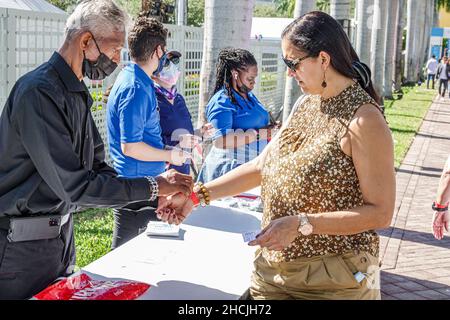 Miami Florida Art Basel Week KONTEXT die Art Miami Show zeigt, wie eine Frau mit Gesichtsmaske den Empfang einer geimpften Covid-19-impfung wr erhält Stockfoto
