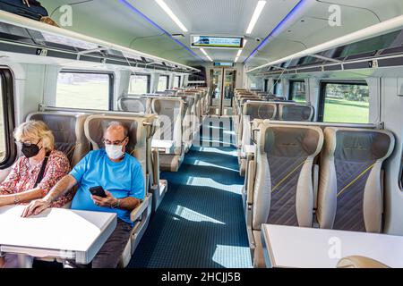 Miami Florida BrightLine Personenzug Bahn Transport Service Nahverkehr trägt Gesichtsmaske Covid-19 Passagierkabine Smart Class man wom Stockfoto