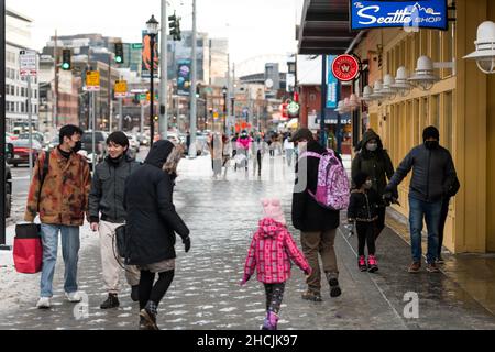 Seattle, USA. 29th Dez 2021. Touristen trotzen dem eiskalten Wetter und Schnee am Wasser, während Omicron-Infektionen in den Vereinigten Staaten weiter steigen. Seattle wurde vor einigen Tagen mit seinem ersten messbaren Winterschnee getroffen und steht nun unter einer eiskalten Wetterwarnung. Omicron ist eine anhaltende Sorge für Gesundheitsbeamte, da die Besorgnis zunimmt, könnte es die dominierende Variante werden. Quelle: James Anderson/Alamy Live News Stockfoto