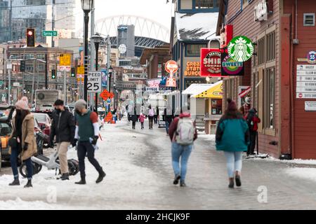 Seattle, USA. 29th Dez 2021. Touristen trotzen dem eiskalten Wetter und Schnee am Wasser, während Omicron-Infektionen in den Vereinigten Staaten weiter steigen. Seattle wurde vor einigen Tagen mit seinem ersten messbaren Winterschnee getroffen und steht nun unter einer eiskalten Wetterwarnung. Omicron ist eine anhaltende Sorge für Gesundheitsbeamte, da die Besorgnis zunimmt, könnte es die dominierende Variante werden. Quelle: James Anderson/Alamy Live News Stockfoto