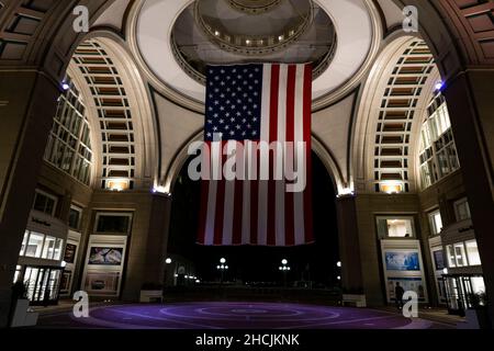 Boston, USA - 22. Oktober 2021: Amerikanische Flagge hängt nachts an der Decke des Untergangs im Hafen von Boston, Massachusetts Stockfoto