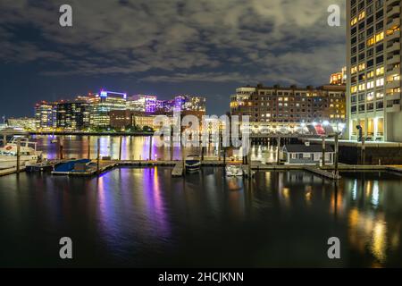 Blick auf die Lichter in den Gebäuden bei Nacht vom Deck des Boston Harbour aus gesehen. Horizont über dem Wasser Stockfoto