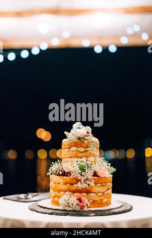 Hochzeit weißen Etagenkuchen auf einem Tisch in der Nacht Stockfoto