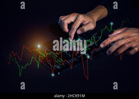 Geschäftsmann, der Finanzstatistiken analysiert, die auf dem Tablet-Bildschirm angezeigt werden. Business Analytics und Finanztechnologiekonzept. Stockfoto