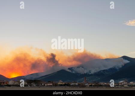 Panoramablick auf ein riesiges Feuer auf dem Monte Pisano in der Nähe von Bientina, Italien, bei Sonnenuntergang Stockfoto