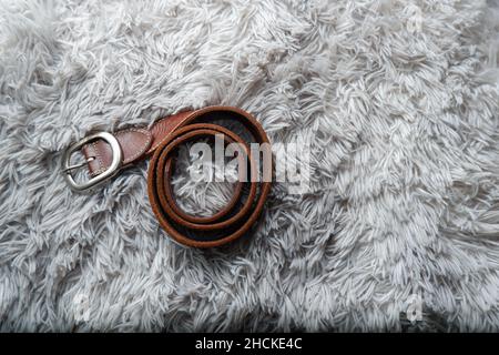 Herren Accessoires brauner Ledergürtel auf grauem Hintergrund Stockfoto