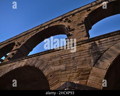 Blick auf das antike römische Aquädukt Pont du Gard mit majestätischen Steinbögen nach Sonnenuntergang in der Nähe von Vers-Pont-du-Gard, Oczitanie, Frankreich mit klarem Himmel. Stockfoto