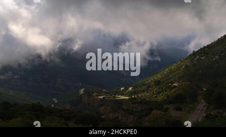 Atemberaubender Blick auf das Massif de la Sainte-Baume in der Region Provence, Frankreich am bewölkten Tag im Herbst mit gewundener Landstraße D2. Stockfoto