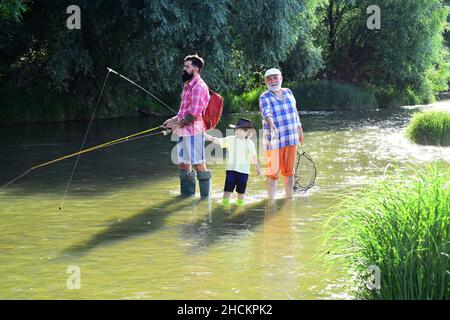 Angeln. Kleiner Junge Fliegenfischen auf einem See mit seinem Vater und Großvater. Angeln im Fluss. Young - Adult Konzept. Stockfoto