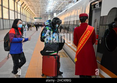 (211230) -- PEKING, 30. Dezember 2021 (Xinhua) -- Passagiere besteigen einen Zug der Hochgeschwindigkeitsstrecke Peking-Zhangjiakou am Pekinger Nordbahnhof in Peking, der Hauptstadt Chinas, am 30. Dezember 2021. Die Hochgeschwindigkeitsbahn, die Peking und Zhangjiakou in der nordchinesischen Provinz Hebei verbindet, wurde am 30. Dezember 2019 in Betrieb genommen. (Foto von Fang Xin/Xinhua) Stockfoto