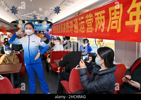 (211230) -- PEKING, 30. Dezember 2021 (Xinhua) -- Ein Besatzungsmitglied tritt am 30. Dezember 2021 in einem Zug der Hochgeschwindigkeitsbahn Peking-Zhangjiakou auf. Die Hochgeschwindigkeitsbahn, die Peking und Zhangjiakou in der nordchinesischen Provinz Hebei verbindet, wurde am 30. Dezember 2019 in Betrieb genommen. (Xinhua/Huang Zhen) Stockfoto