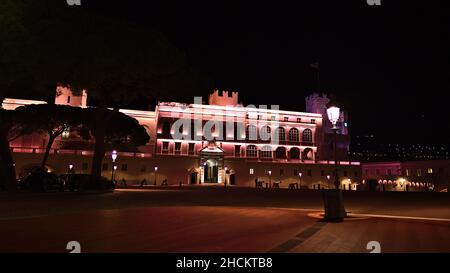 Idyllische Nachtansicht des berühmten Fürstenpalastes von Monaco (Residenz von Prinz Albert II.) an der französischen Riviera mit beleuchteter Fassade und Straßenlaterne. Stockfoto