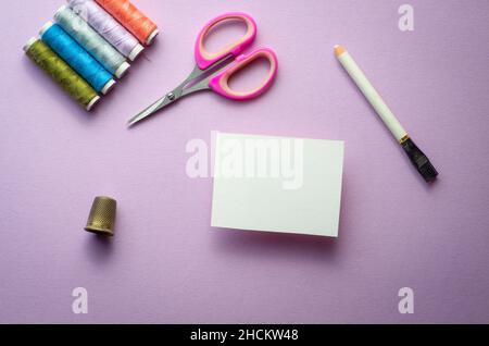 Mockup Visitenkarte für Nähen oder Textil, Schneider oder hausgemachte. Auf mauve Hintergrund. Stockfoto