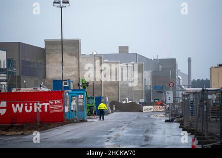 30. Dezember 2021, Brandenburg, Grünheide: Ein Wachmann steht am Eingang zum zukünftigen Tesla Gigafactory Berlin Brandenburg. Tesla hat nach Angaben der Landesregierung Brandenburg die fehlenden Unterlagen für das Genehmigungsverfahren eingereicht. Foto: Christophe Gateau/dpa Stockfoto