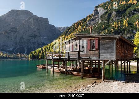 Die Holzhütte auf Pfosten mit dem Bootsverleih am Pragser See vor dem Seekofel in den Dolomiten, Südtirol, Italien Stockfoto