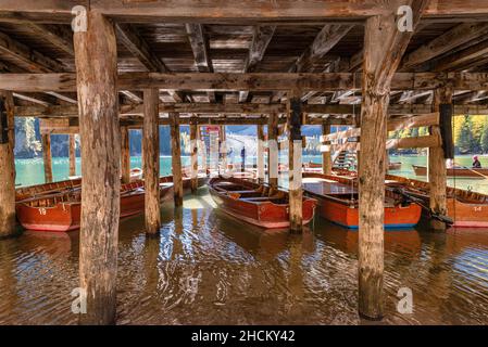 Ruderboote auf Holzstangen unter der Holzhütte mit dem Bootsverleih am Pragser See in den Dolomiten, Südtirol, Italien Stockfoto