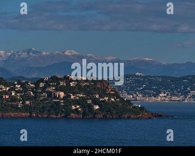 Atemberaubender Panoramablick auf die felsige mittelmeerküste vom Cap Roux in der Nähe von Saint-Raphael, Französische Riviera, Frankreich mit schneebedeckten Bergen. Stockfoto