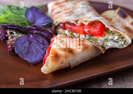 Lavasch mit Käse und Kräutern auf einem Brett Stockfoto