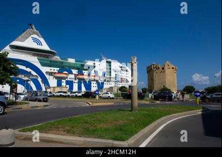 Europa, Italien, Sardinien, Porto Torres, Torre Aragonese am Hafen mit dem Kreuzschiff im Hintergrund Stockfoto