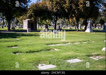 Nahaufnahme der Grabsteine auf einem Friedhof mit Bäumen Stockfoto