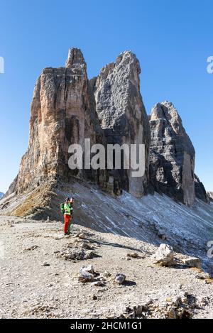 Ein Mann und eine Wanderin stehen am Paternsattel vor den Zinnen der drei Zinnen in den Sextener Dolomiten, Südtirol, Italien Stockfoto