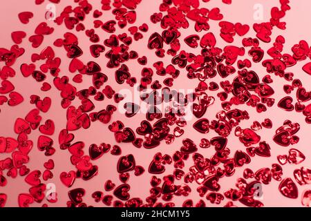 Draufsicht auf leuchtend rote Konfetti-Herzen auf rosa Stockfoto