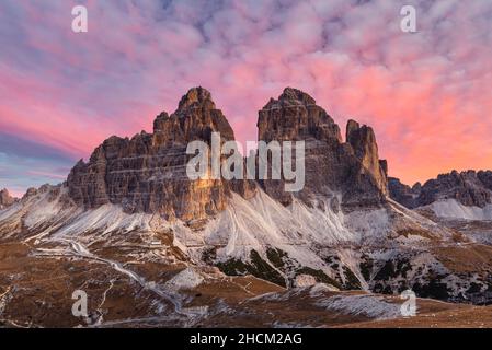 Wolken und die südlichen Felswände der drei Zinnen Tre Cime di Lavaredo in den Sextener Dolomiten glühen bei Sonnenaufgang, Südtirol, Italien Stockfoto