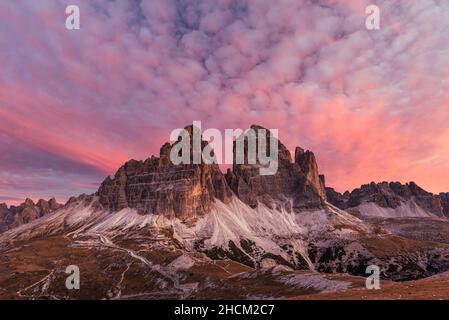 Wolken und die südlichen Felswände der drei Zinnen Tre Cime di Lavaredo in den Sextener Dolomiten glühen bei Sonnenaufgang, Südtirol, Italien Stockfoto