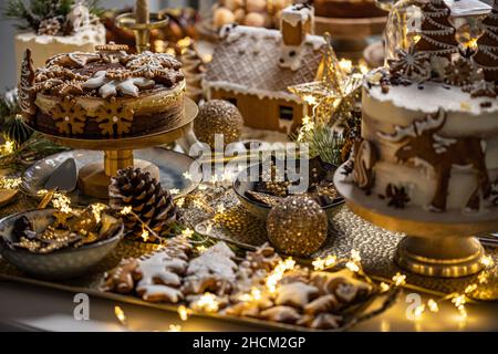 Vielfalt an leckeren appetitlich süßen Desserts, Kuchen mit Creme, Schokolade, Lebkuchen auf dem festlichen Weihnachtstisch Stockfoto